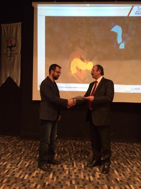 Chapter President Kamil Zafer Selçuk presents the certificate of appreciation to Turgut at the December meeting.